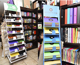 Dos estanterías con carpesanos, libretas y libros de lectura.